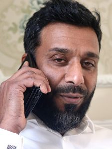 Man with beard, speaking on phone