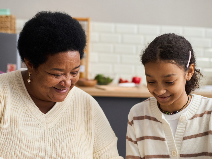 Grandmother and daughter sat at kitchen table